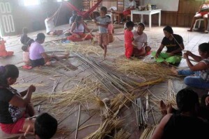 Encontros entre jovens e anciãs promovem a transmissão dos saberes ancestrais da cestaria tradicional e fortalecem a autonomia das mulheres no rio Tapauá. (Mulheres Paumari reunidas durante os encontros de produção do artesanato. (Fotos: Talita Oliveira/OPAN).